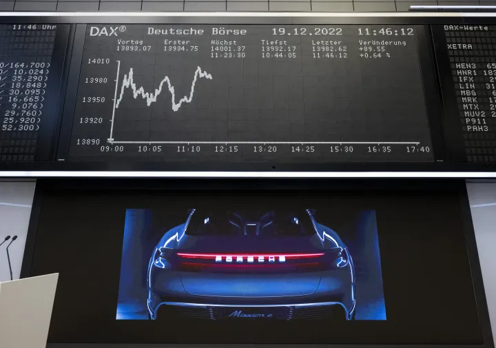 Az autógyártó DAX tőzsdei debütálásán egy Porsche képe látható a cég részvényeinek ártáblája alatt 2022. december 19-én – Fotó: Hannes P Albert / picture alliance / Getty Images