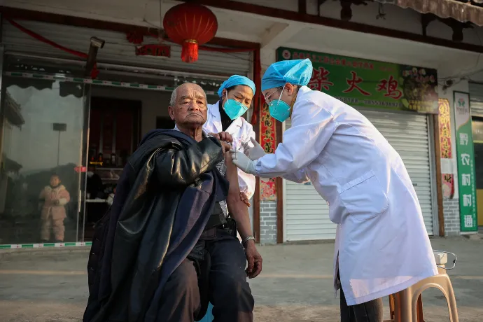 Kínai egészségügyi dolgozók koronavírus elleni oltást adnak be 2022. december 12-én – Fotó: AFP 