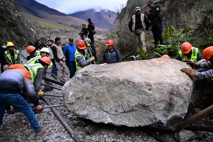 Munkások megpróbálják eltávolítani a tüntetők által a Machu Picchu felé vezető vasúti sínekre helyezett sziklát 2022. december 17-én – Fotó: Martin Bernetti / AFP
