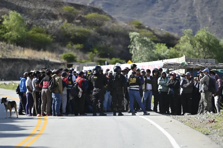 Rendőrök tárgyalnak Pedro Castillo volt elnököt támogató földművesekkel, akik blokádot tartanak egy perui autóúton 2022. december 19-én – Fotó: Martin Bernetti / AFP