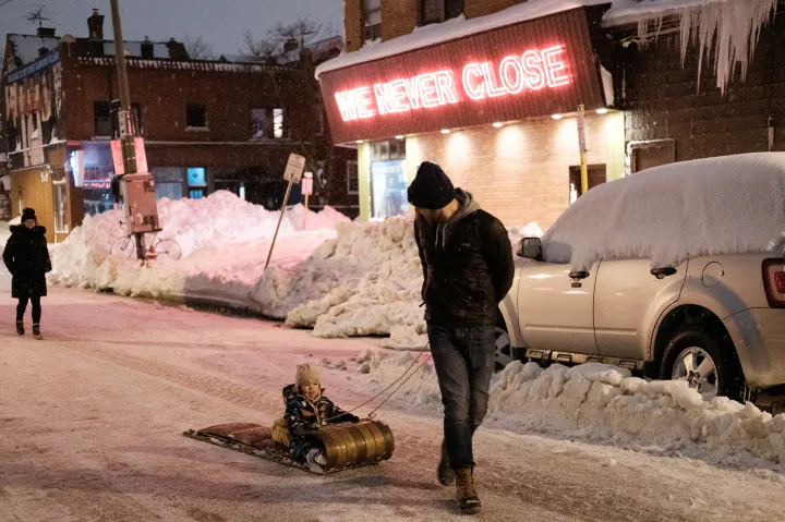 Vízvezeték javítása, hóval borított autók és szánkózó család Buffalo belvárosában – Fotó: Joed Viera / AFP