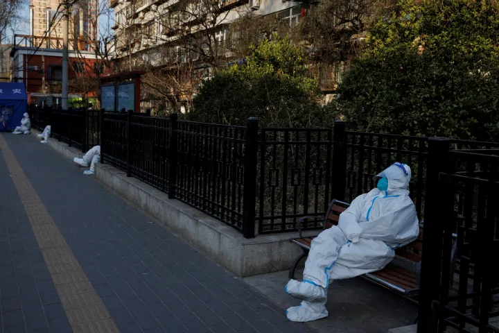 Járványmegelőzési dolgozók a műszakjukra várnak olyan pekingi épületek előtt, ahol a karanténba helyezett lakosokat kell megfigyelniük, 2022. december 8-án – Fotó: Thomas Peter / Reuters