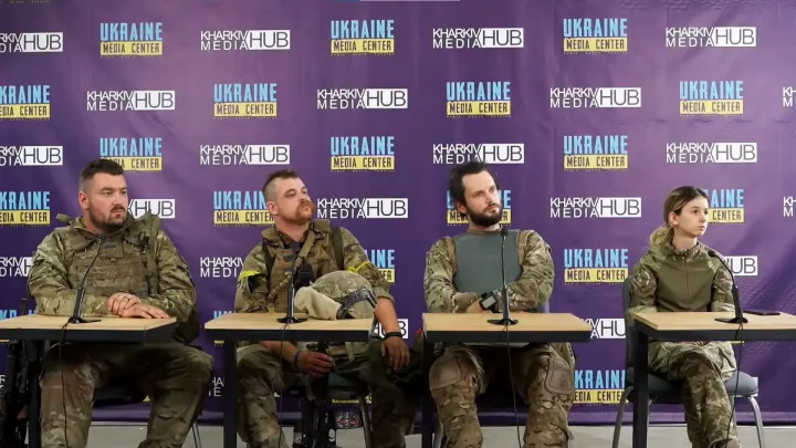 Fajk Emese (jobbra) és három külföldi légiós katona egy ukrajnai sajtótájékoztatón, 2022. júl. 8-án – Képernyőmentés a Ukraine Media Center Youtube-videójából