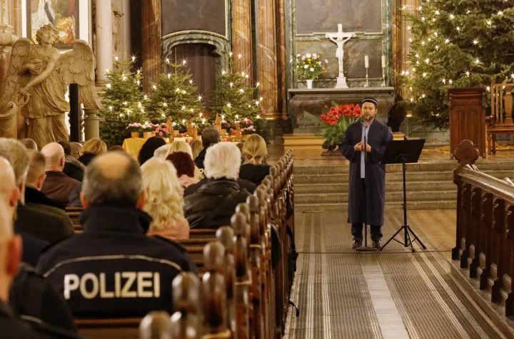 Ender Cetin imám mond beszédet a berlini Szent Mária templomban, ahol ökumenikus szertartáson imádkoztak a szilveszteri zavargások idején szolgálatban lévőkért – Fotó: Carsten Koall / DPA / AFP