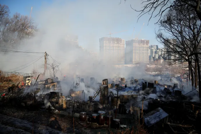 A gurjongi tűz megfékezésén dolgozó tűzoltók és a lángok martalékává lett nyomornegyed egy része – Fotó: Kim Hong-dzsi / Reuters / Yonhap News Agency