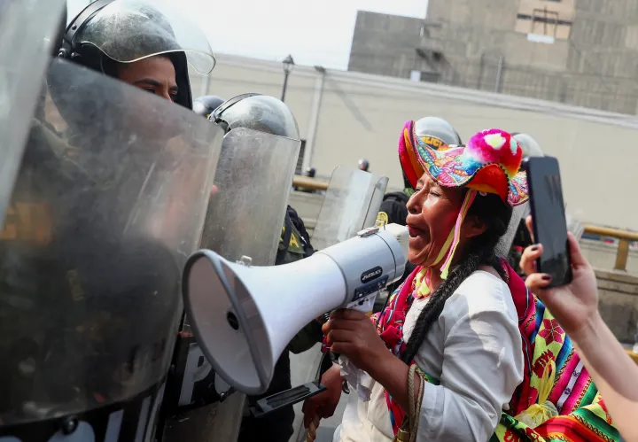 Egy tüntető és rohamrendőrök egy kormányellenes tüntetésen a perui Limában, 2023. január 21-én – Fotó: Pilar Olivares / Reuters