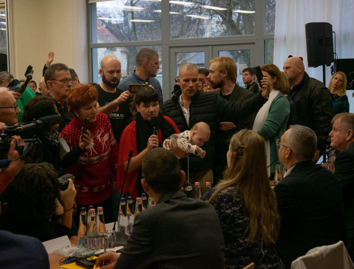 Nő a csecsemőjét tartja Kovács Mónika és (jobbján) Rácz Róbert főispán elé. Fotó: Szabó Milán