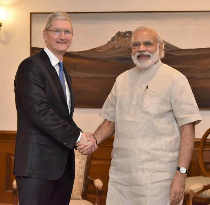 In this handout photograph released by The Indian Press Information Bureau (PIB) on May 21, 2016, Indian Prime Minister Narendra Modi(R)shakes hands with Apple CEO Tim Cook during a meeting in New Delhi on May 21, 2016. – Apple chief executive Tim Cook met with Prime Minister Narendra Modi in New Delhi , launching a new version of the Indian leader's eponymous app on a visit aimed at pushing the technology giant's expansion plans. Cook, shown in a video using the premier's gold-coloured iPhone, launched an update to the Narendra Modi Mobile App to include a new volunteering network, the government said. (Photo by HO / PIB / AFP) / RESTRICTED TO EDITORIAL USE – MANDATORY CREDIT
