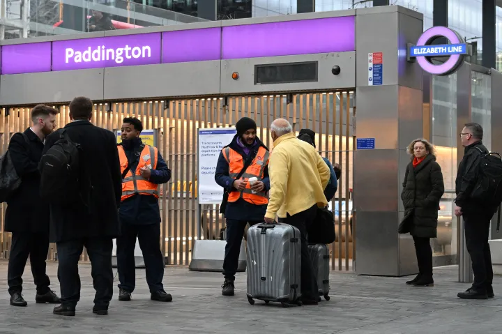 Hoppon maradt utasok beszélgetnek vasúti dolgozókkal a sztrájk miatt lezárt Paddington vasútállomás előtt, Londonban, 2023. január 12-én – Fotó: Justin Tallis / AFP
