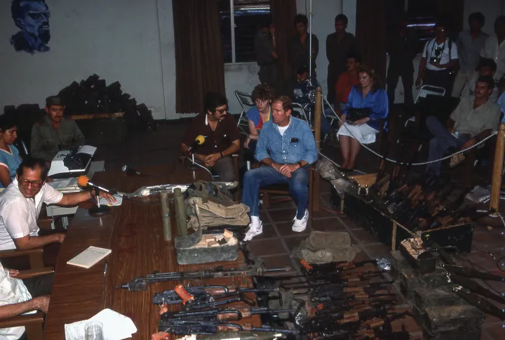 Eugene Hasenfus az 1986. október 1-i tárgyalásán (középen farmeringben), körülötte a lelőtt gépről származó fegyverek – Fotó: Kaveh Kazemi / Getty Images
