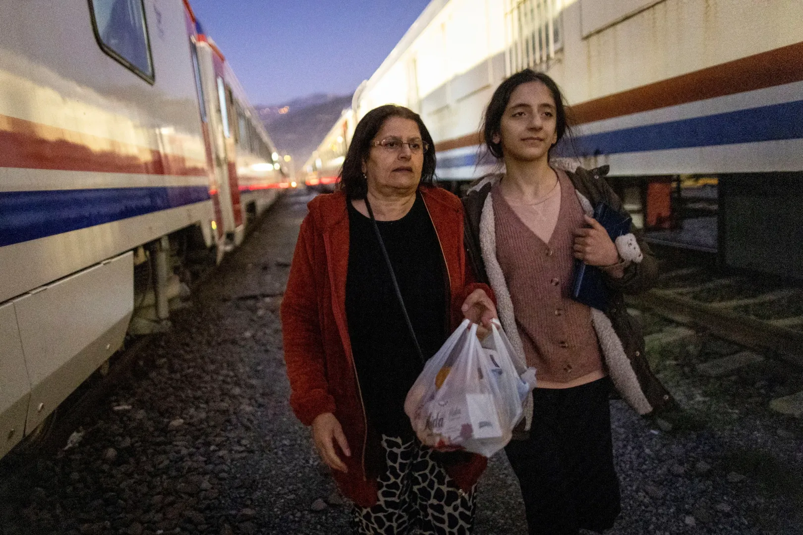 Sabriye Karan és lánya, Nehir ideiglenes szállásukra tartanak a vágányok között – Fotó: Eloisa Lopez / Reuters