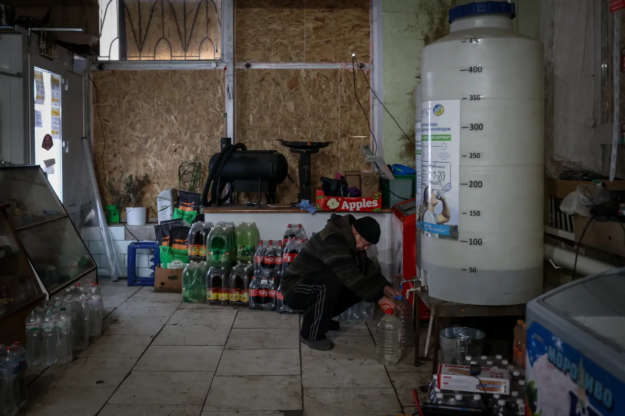 Antonyina golyóálló mellényben a pult mögött a boltban, amely sokaknak az egyetlen ivóvízforrás Orihivben – Fotó: Huszti István / Telex