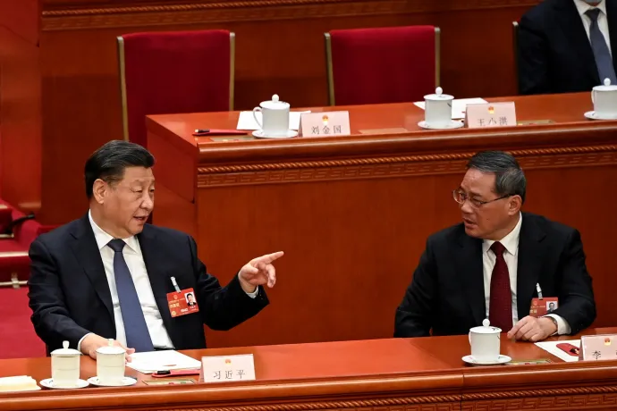 Hszi Csin-ping elnök-pártfőtitkár magyaráz a 2023. március 11-i Országos Népi Gyűlésen Li Csiangnak, aki figyelmesen hallgat – Fotó: Greg Baker / Pool via Reuters