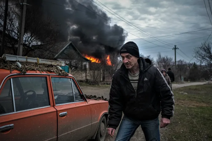 Helyi lakos egy lángoló épület mellett egy orosz rakétázást követően a Donyeck megyei Konsztantyinovkában 2023. március 15-én – Fotó: Sergey Shestak / AFP