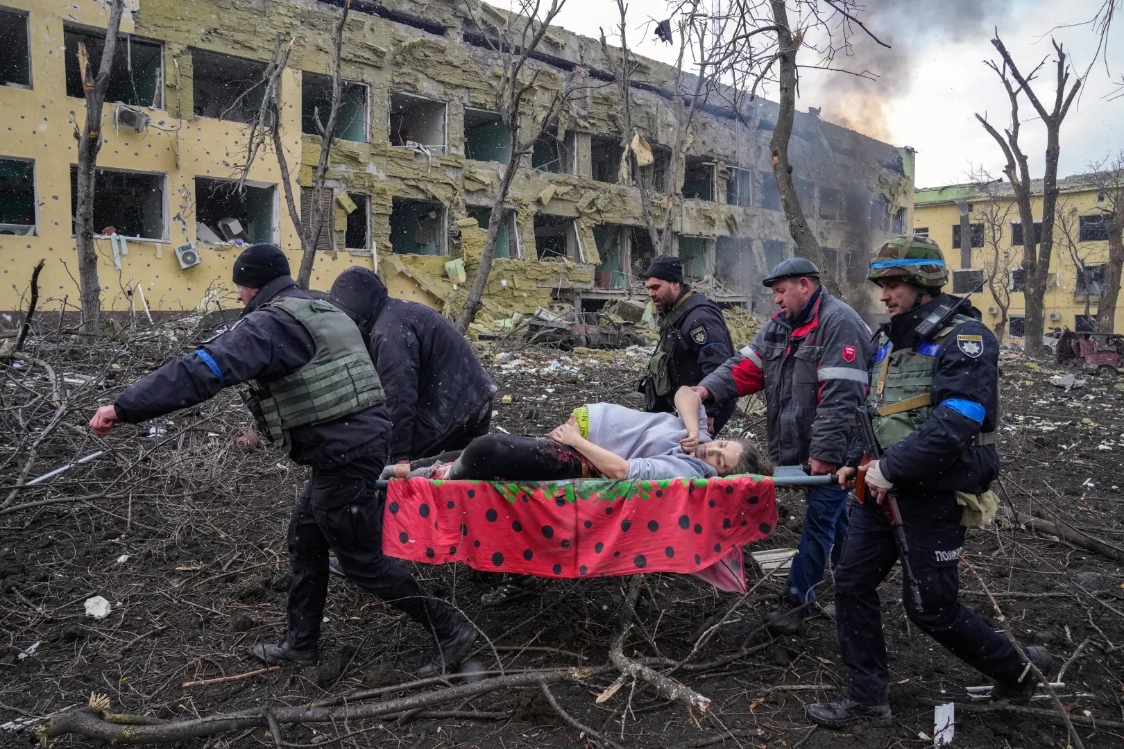 A 32 éves, terhes és sebesült Irina Kalininát viszik ki egy mariupoli szülészetről egy orosz rakétatámadás után 2022. március 9-én. A Miron névre keresztelt fia halva született, Irina fél órával a szülés után meghalt. Az Európai Biztonsági és Együttműködési Szervezet (EBESZ) jelentése szerint a kórházat szándékosan rakétázta Oroszország. Hárman meghaltak, tizenheten megsérültek a támadásban