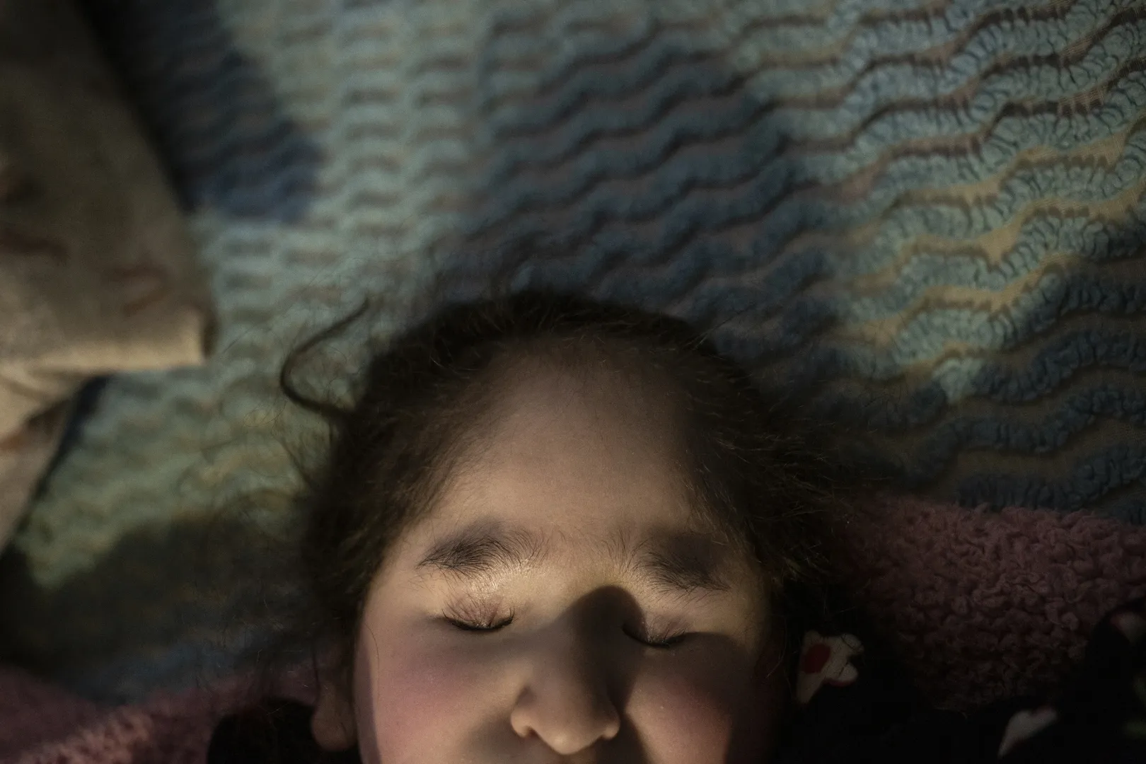 A 16 éves Carmelita az ágyán fekszik a mexikói Villa Guerreróban, 2021. november 21-én. Carmelita encefalomaláciától, azaz agyi szövet lágyulásától szenved. Az állapota miatt annyira érzékeny, hogy fájdalmat okoz neki, ha kimegy a fényre