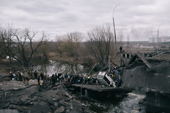Civilek evakuálása egy felrobbantott hídon keresztül Irpinyben, a vasútvonal lebombázása után. Fotó: Makszim Dongyuk