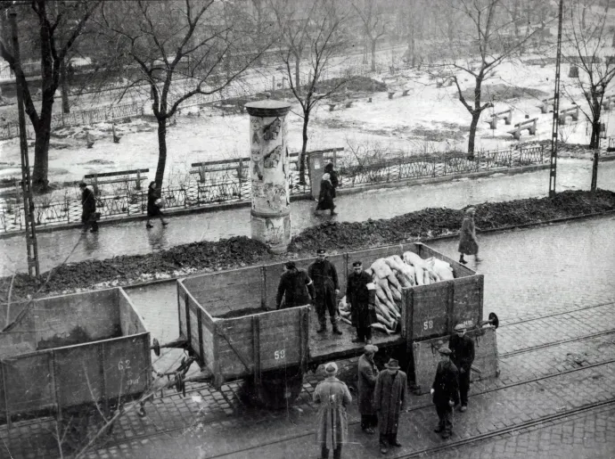 Holttesteket szállítanak a villamossíneken közlekedő vasúti kocsikon a pesti gettóból 1945-ben. A fotó a Törvényszéki Orvostani Intézet (ma Semmelweis Egyetem Igazságügyi és Biztosítás-orvostani, valamint II. sz. Patológiai Intézet) ablakából készült – Fotó: Fortepan