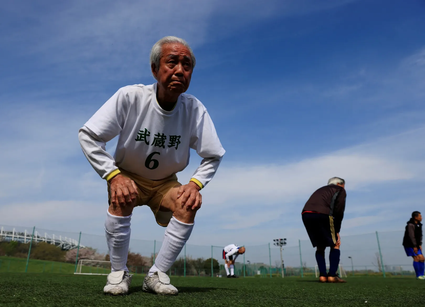 A 83 éves Nomura Mucuhiko nyújt a csapattagjaival – Fotó: Kim Kyung-Hoon / Reuters