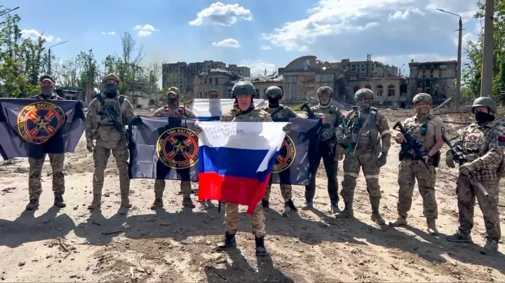 Jevgenyij Prigozsin sajtószolgálata által közreadott, videófelvételről készített kép Prigozsinról, a Wagner orosz magánhadsereg alapítójáról (k) egy orosz zászlóval a kezében és a katonáiról Bahmutban 2023. május 20-án – Fotó: Jevgenyij Prigozsin sajtószolgálata / AP / MTI