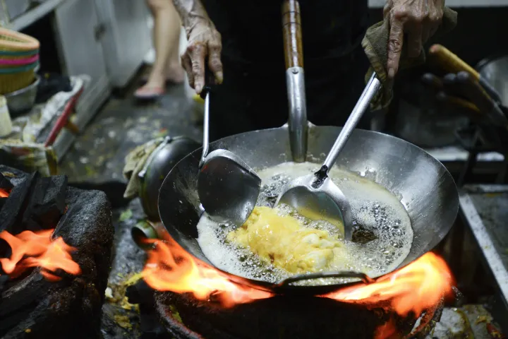 Wokban sül éppen valami egy bangkoki konyhában – Fotó: Anusak Laowilas / NurPhoto via AFP