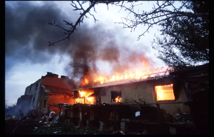 Szerb rendőrök felgyújtották az általuk elfoglalt házat, mielőtt elhagyták koszovói állomáshelyüket a NATO-val kötött megállapodás értelmében, 1998. október 26-án – Fotó: Roger Lemoyne/Liaison / Getty Images