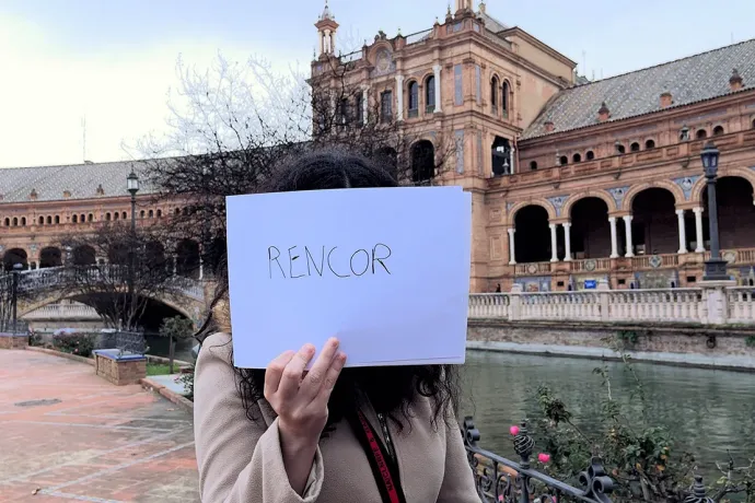 Egy érintett spanyol nő „rencor" vagyis „neheztelés/harag/düh" szót mutató táblával a kezében – Fotó: Lucía Riera és Laura Llach / Journalismfund