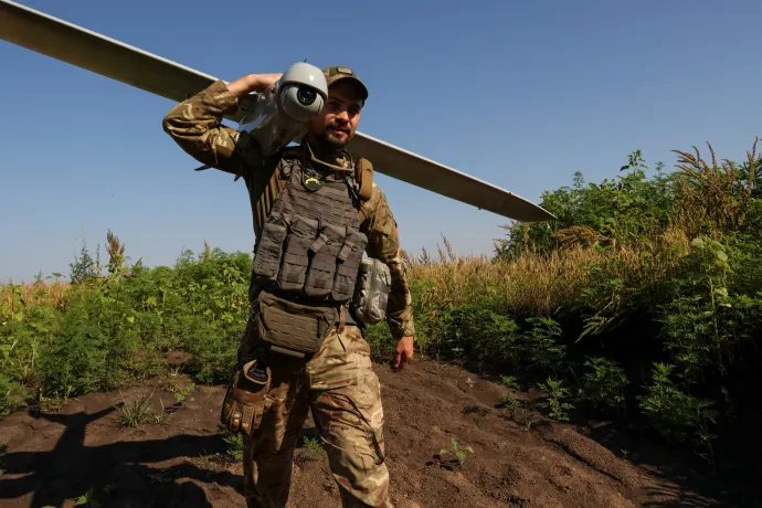 Egy ukrán katona egy felderítő pilóta nélküli légi járművet visz a frontvonal közelében lévő kilövőállásra a Donyeck régióban, 2023. július 6-án – Fotó: Sofiia Gatilova / Reuters