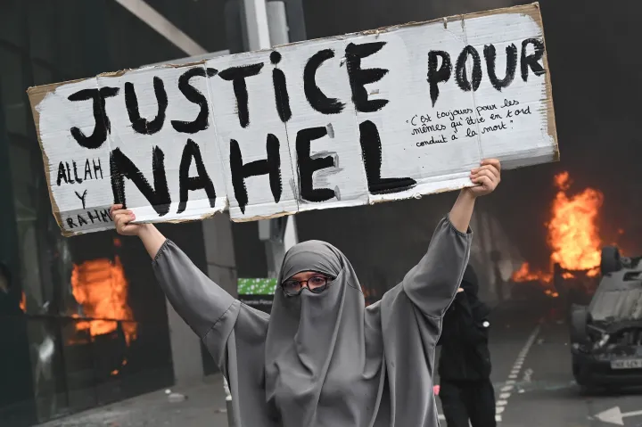 Egy résztvevő „Igazságot Nahelnek” feliratú transzparenst tart egy zavargásba fulladt megemlékezés végén Párizs külvárosában, Nanterre-ben, 2023. június 29-én – Fotó: Bertrand Guay / AFP