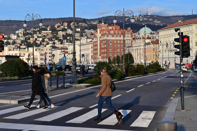 A picture taken on January 18, 2021 shows people crossing the Riva Tre Novembre avenue close to the Piazza Unita d'Italia during the COVID-19 pandemic caused by the novel coronavirus. (Photo by MIGUEL MEDINA / AFP)