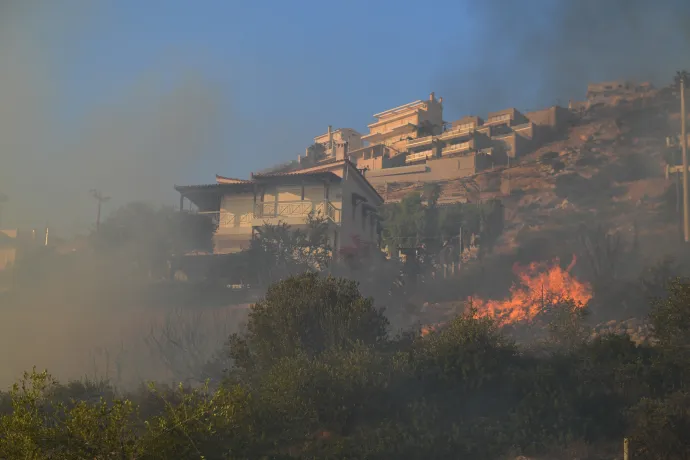 Tűzoltók oltanak egy erdőtűzben égő házat a délkelet-attikai Lagonisziben – Fotó: Dimitris Lampropoulos / 2023 Anadolu Agency