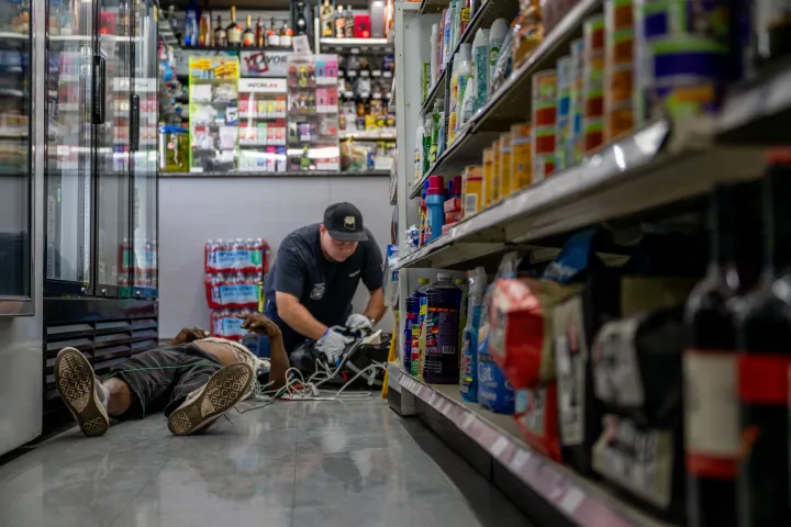 Egy ember orvosi ellátást kap, miután összeesett a hőség miatt egy kisboltban, 2023. július 13-án, Phoenixben, Arizonában – Fotó: Brandon Bell / Getty Images