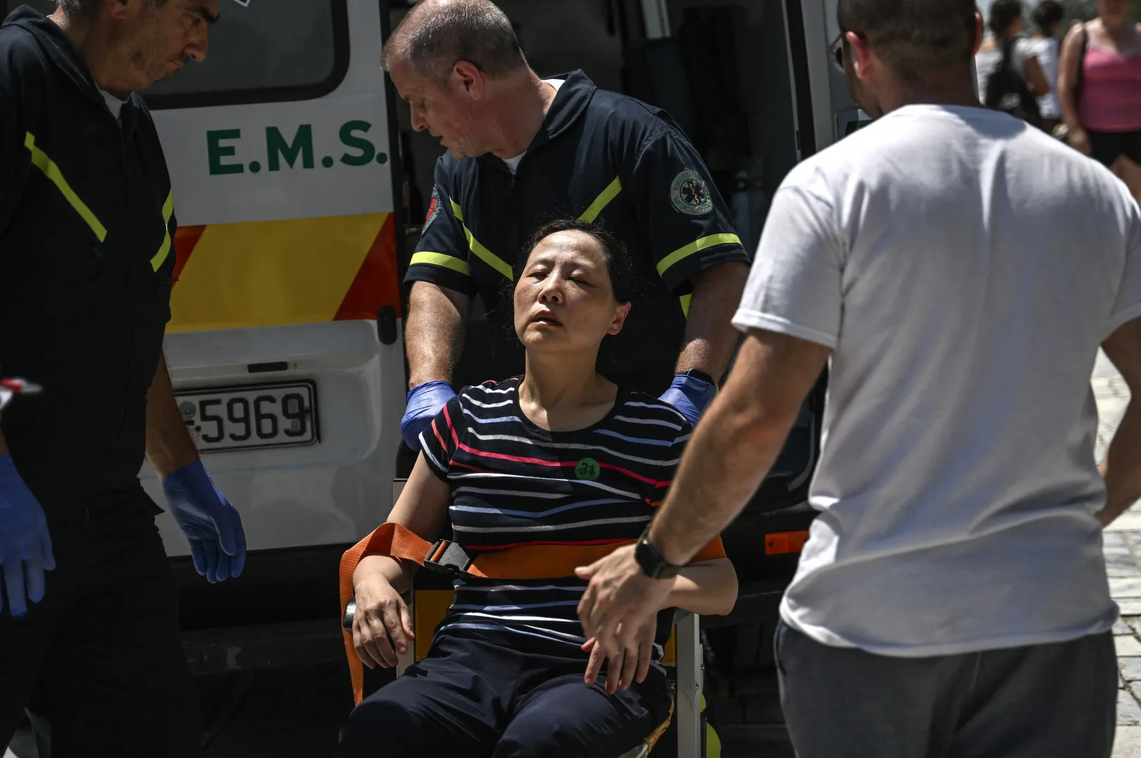 Mentőmunkások egy turistát tesznek mentőautóba az Akropolisznál – Fotó: Angelos Tzortzinis / AFP