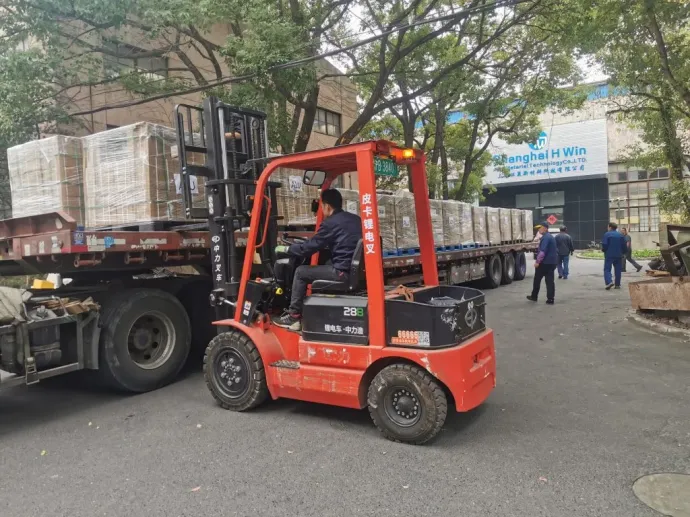 Kész terméket pakolnak kamionra a golyóálló mellényeket és sisakokat gyártó Shanghai H Win vállalat udvarán – Fotó: Shanghai H Win