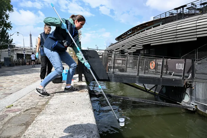 A Fluidion cég egyik alkalmazottja vízmintát vesz a Szajnából, hogy elemezze annak összetételét – Fotó: Bertrand Guay / AFP