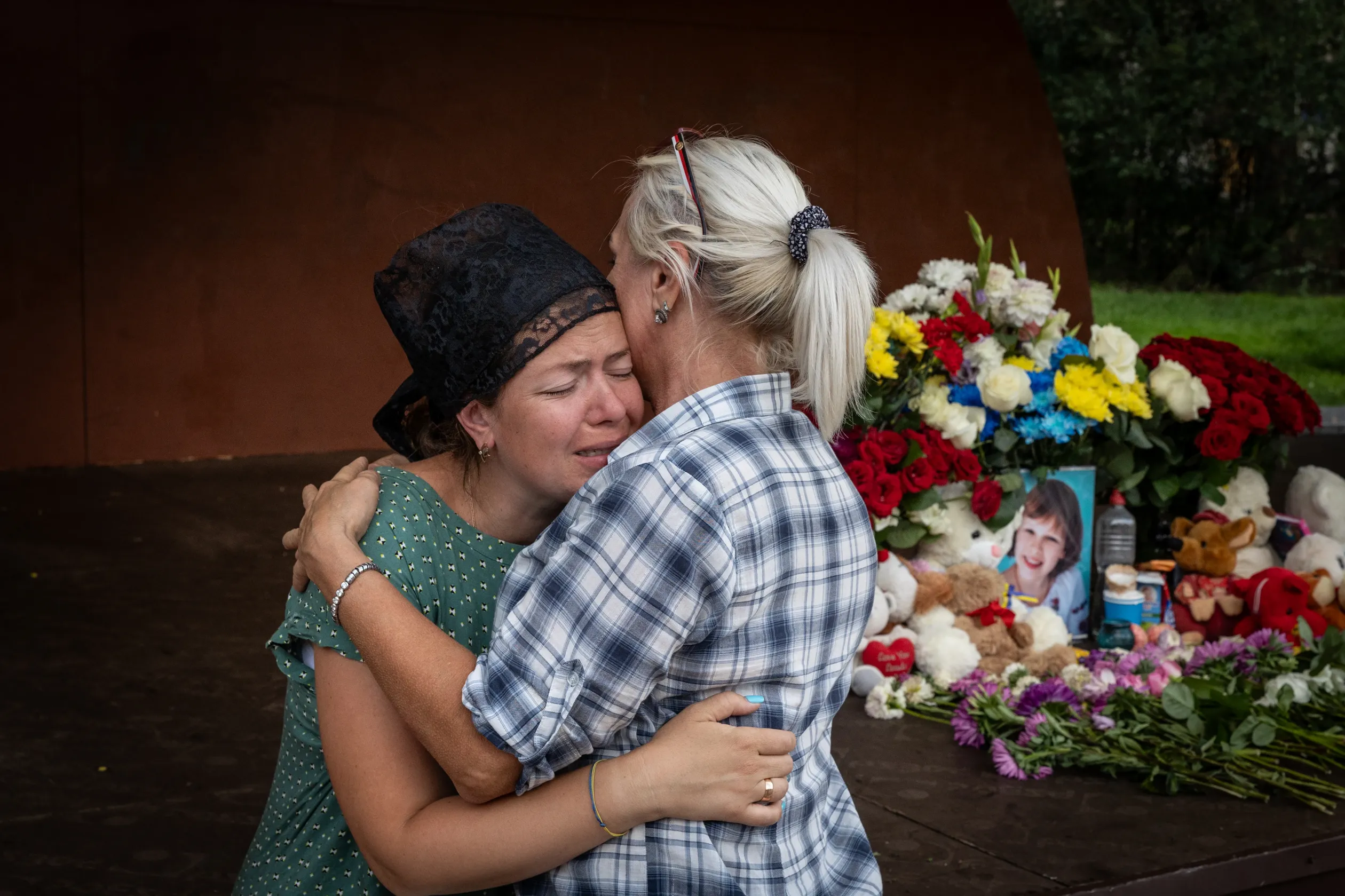 Szofija édesanyjának, Olga Holinszkának egy járókelő nyilvánít részvétet a tragédia helyszínén – Fotó: Huszti István / Telex