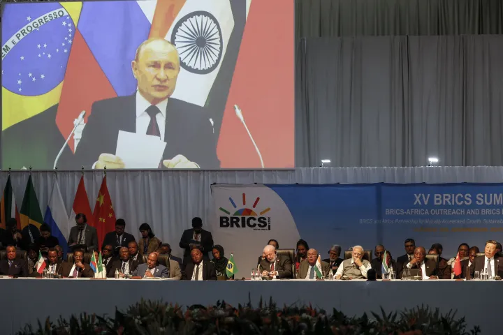 Vlagyimir Putyin orosz elnök kivetítőn keresztül mond beszédet a 2023-as BRICS-csúcstalálkozón, a johannesburgi Sandton Kongresszusi Központban, augusztus 24-én – Fotó: Marco Longari / AFP
