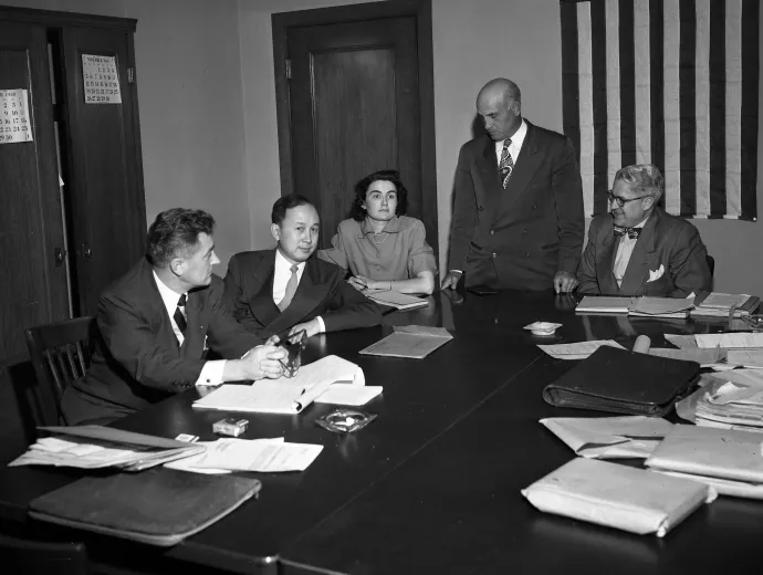 A Caltech tudósának kitoloncolási meghallgatása a bevándorlási hivatalban 1950. november 16-án. A képen Grant B. Cooper, Dr. Csien ügyvédje, Csien Hszüe-szen, a meghallgatás jegyzőkönyvvezetője, Albert Del Guercio, vizsgálóbiztos és Ray Waddell, meghallgatóbiztos – Fotó: Los Angeles Times / UCLA Library Special Collections (CC BY 4.0)