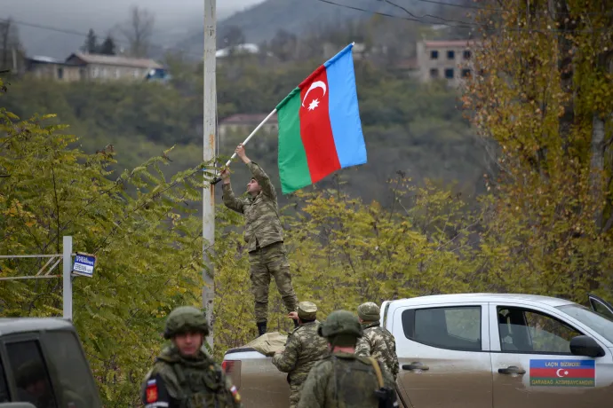 Azerbajdzsáni katona nemzeti zászlót rögzít egy lámpaoszlopra Laçın városában – Fotó: Karen Minasyan / AFP