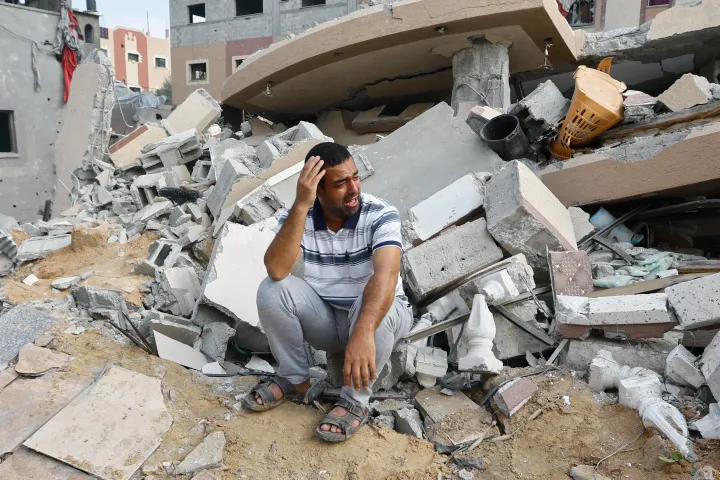 Palesztin féri egy izraeli csapásokban lerombolt ház romjai mellett Khan Júniszban, a Gázai övezet déli részén, 2023. október 8-án – Fotó: Ibraheem Abu Mustafa / Reuters