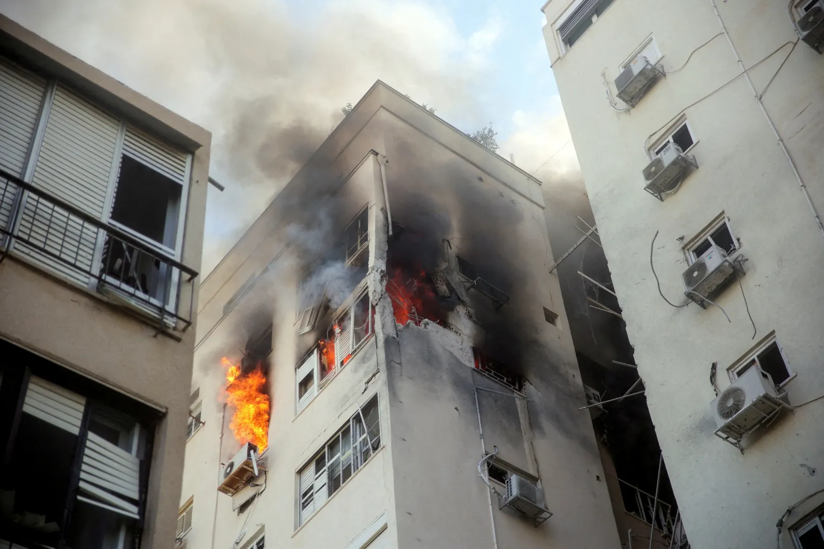 Épület lángol az izraeli Tel-Avivban, miután eltalált egy, a Gázai övezetből október 7-én indított rakéta – Fotó: Itai Ron / Reuters