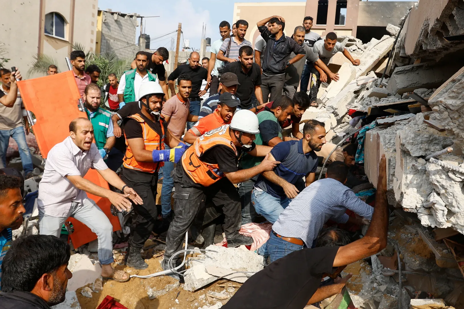 Palesztinok áldozatok után kutatnak egy izraeli csapásokban lerombolt ház romjai alatt Khan Yunisban, a Gázai övezet déli részén – Fotó: Ibraheem Abu Mustafa / Reuters