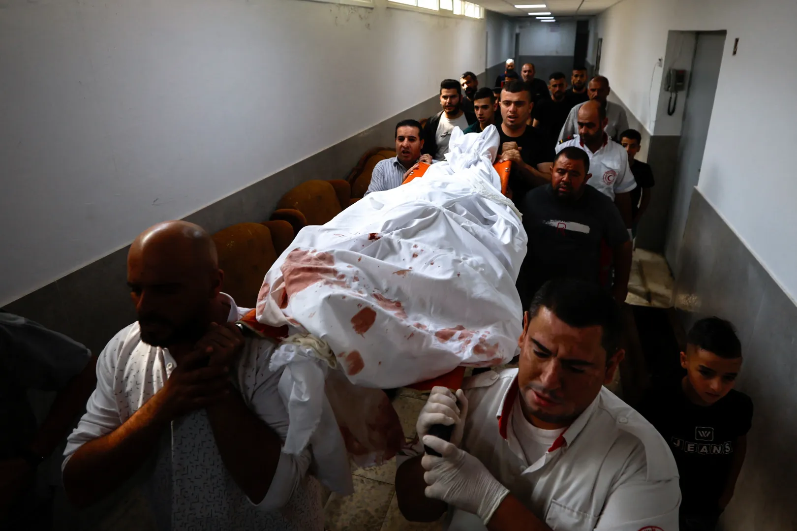 Temetése előtt férfiak cipelik az izraeli erőkkel való összecsapásokban megölt palesztin Juszef Idrisz holttestét, az izraeli megszállás alatt álló ciszjordániai Hebron egyik kórházában – Fotó: Mussa Issa Qawasma / Reuters