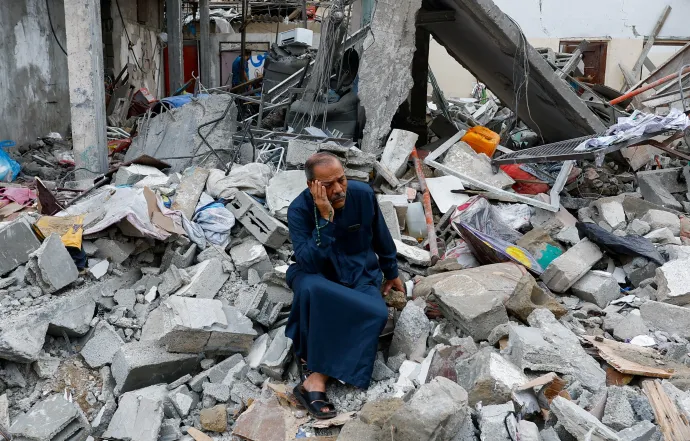 Egy palesztin ül az izraeli csapásokban lerombolt épület romjain a Gázai övezet déli részén fekvő Rafahban 2023. október 9-én – Fotó: Ibraheem Abu Mustafa / Reuters