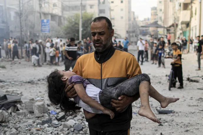 Egy palesztin férfi egy sérült kislányt cipel – Fotó: Yasser Qudih / AFP
