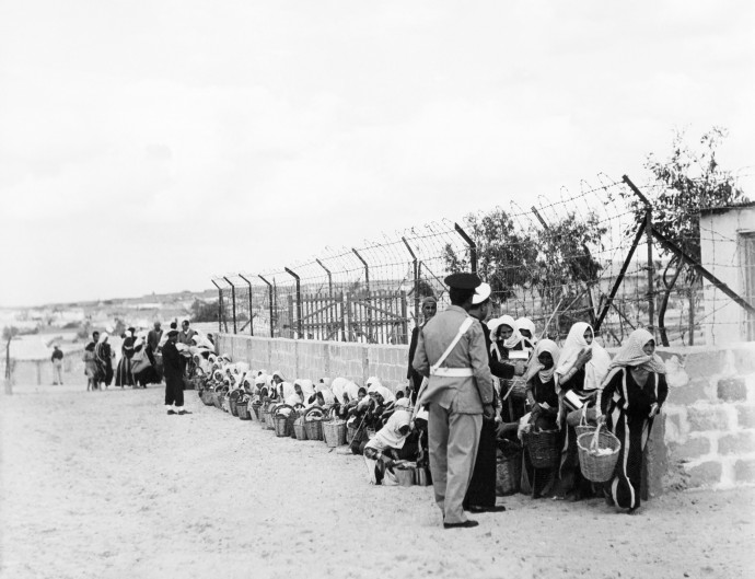 Palestinian refugees queue for food distributed by the UNRWA (UN Relief and Work Agency for Palestinian refugees) at a camp in Gaza 09 November 1956.Des réfugiés palestiniens attendent la distribution de nourriture effectuée par l'UNWRA (Agence des Nations unies de secours aux réfugiés palestiniens) dans un camp de Gaza le 09 novembre 1956. (Photo by RENE JARLAND / AFP)