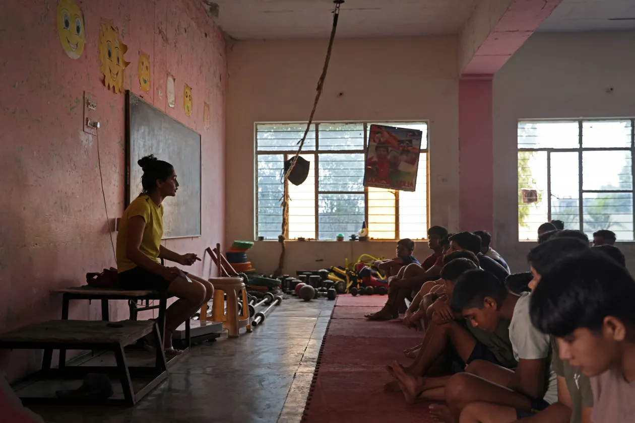 A 28 éves Naveen Sihag birkózóedző beszél a diákokhoz az edzőteremben. A 27 éves Sonu Kaliraman húgával, a 21 éves Neelam Kaliramannal – Fotó: Anushree Fadnavis / Reuters
