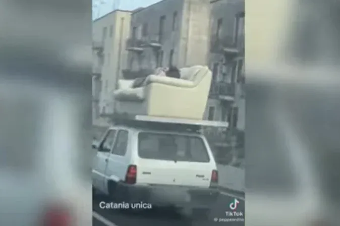 Városnézés extra: a kocsi tetejére szíjazott kanapén pihente ki a cipekedés fáradalmait egy olasz férfi