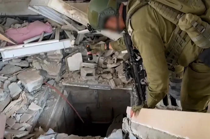 Az izraeli hadsereg egyik november 3-án publikált videójábólkivágott képen egy izraeli katona figyeli a Hamász egyik alagútnyílását Fotó:IDF via AFP