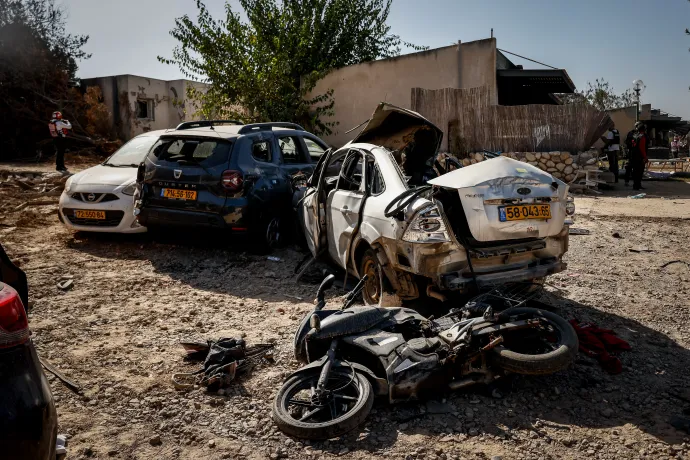 A Kfar Aza kibuc beszakított kapuja, háttérben a Gázai övezet, ahonnan a terroristák érkeztekoktóber 7-én, hogy lemészárolják a település lakóit. A kiégett autók mellett egy robogó, amivel az egyik Hamász-fegyveres érkezett – Fotó: Huszti István / Telex